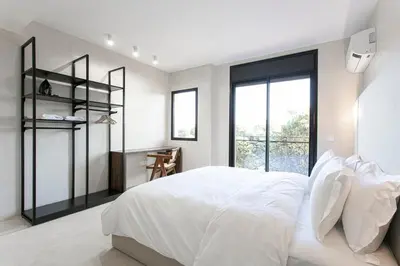 a white bedroom with a large bed and a window at The view City Center in Marrakech