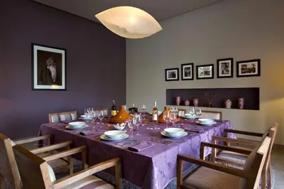a dining room table with a purple table cloth at Villa de luxe avec piscine sur le golf d'amelkis in Marrakech