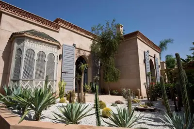 a house with a lot of plants in front of it at Villa de luxe avec piscine sur le golf d'amelkis in Marrakech