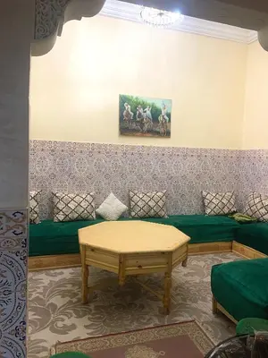 a living room with a green couch and a table at Maison Marrakech in Marrakech