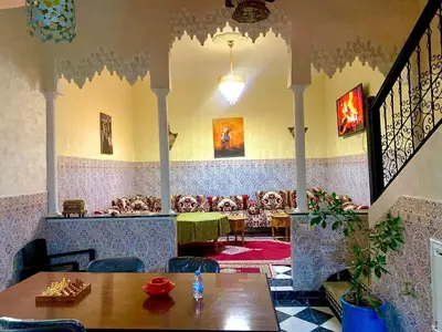 a restaurant with a table and chairs and a couch at Maison Marrakech in Marrakech
