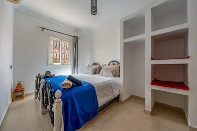 a bedroom with a bed with a blue blanket at New Stylish Riad - 4BR with Pool Access in Marrakech