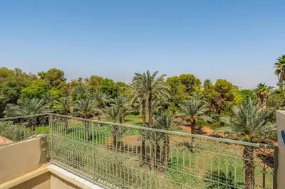 a view from the balcony of a resort with palm trees at New Stylish Riad - 4BR with Pool Access in Marrakech