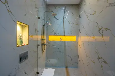 a shower in a bathroom with a marble wall at Villa Mareva & Spa Marrakech in Marrakech