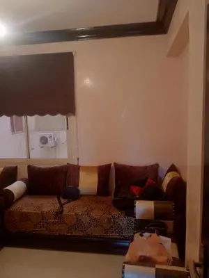 a living room with a couch with pillows at Appart 2 CH lumineux et une piscine pour votre séjour in Marrakech