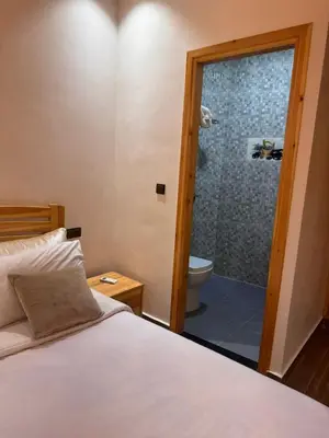 a bedroom with a bed and a bathroom with a shower at Villa cosy & pool Marrakech in Marrakech