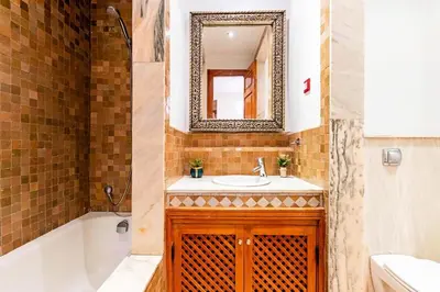 a bathroom with a sink and a tub and a mirror at Palmeraie - Open Garden & Pool in Marrakech