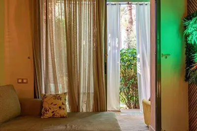 a living room with a sliding glass door to a patio at Palmeraie - Open Garden & Pool in Marrakech