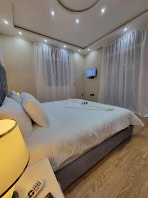 a bedroom with a large bed with a tv on the wall at Villa Marrakech Rimass - 6 Chambres Dont 5 Suites Luxe, Piscine Privee & Jardins in Marrakech