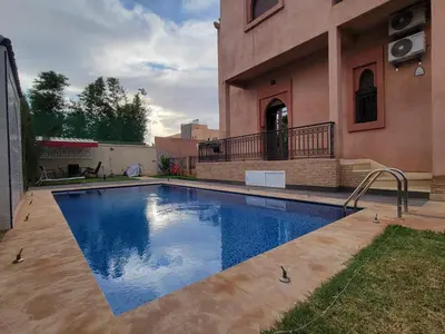 a swimming pool in front of a house at Villa Marrakech Rimass - 6 Chambres Dont 5 Suites Luxe, Piscine Privee & Jardins in Marrakech