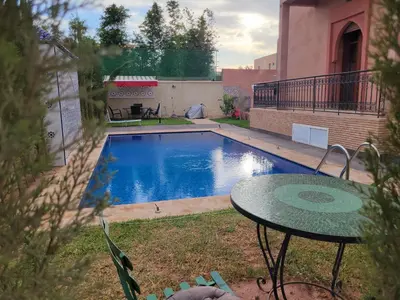 a small swimming pool in a yard with a table at Villa Marrakech Rimass - 6 Chambres Dont 5 Suites Luxe, Piscine Privee & Jardins in Marrakech