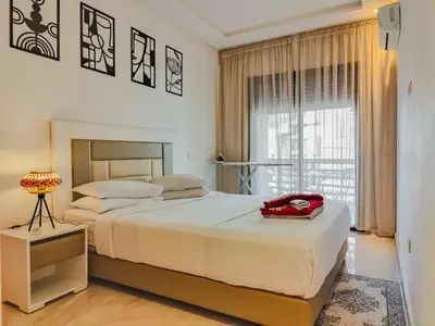 a bedroom with a large bed with a red bag on it at Luxury Aprt 2-bedrooms-Pool Hivernage City Centre-Free Parking in Marrakech