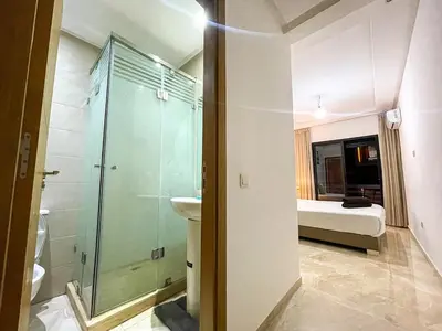 a bathroom with a shower and a toilet and a bed at Luxury Aprt 2-bedrooms-Pool Hivernage City Centre-Free Parking in Marrakech
