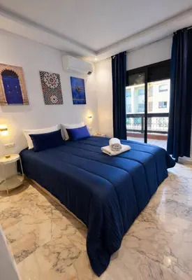 a bedroom with a blue bed with a hat on it at Appartement 2 chambres à Guéliz avec terrasse et parking in Marrakech