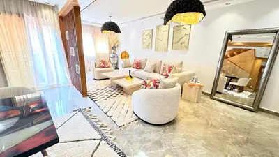a living room with a white couch and a mirror at Luxury HIRONDELLE duplex Marrakech 175 m in Marrakech