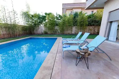 a patio with two chairs and a swimming pool at Villa 3 in Marrakech