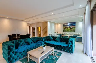 a living room with a blue couch and a table at Villa 3 in Marrakech
