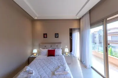 a bedroom with a large bed and a large window at Villa 3 in Marrakech