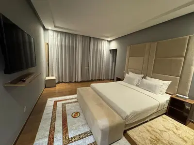 a bedroom with a large bed and a television at Villa 5 in Marrakech
