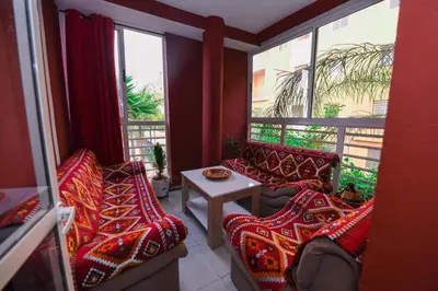 a room with two couches and a table and windows at Jardin de chrifia cosy in Marrakech