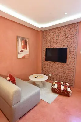 a living room with a couch and a flat screen tv at Suite Safran - Ambiance berbere in Marrakech