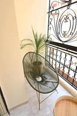 a chair in a room with a plant at Suite Ivoire - Elegance a Gueliz in Marrakech