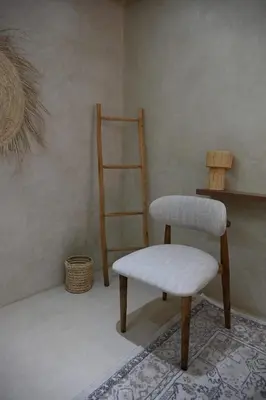 a chair and stool in a room with a shelf at Suite Dune - Confort et Elegance in Marrakech