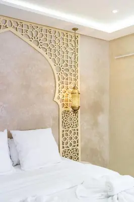 a bedroom with a white bed and a wall at Suite Oxyde - Elegance douce in Marrakech