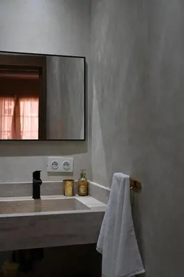 a bathroom with a sink with a mirror and a towel at Suite Oxyde - Elegance douce in Marrakech
