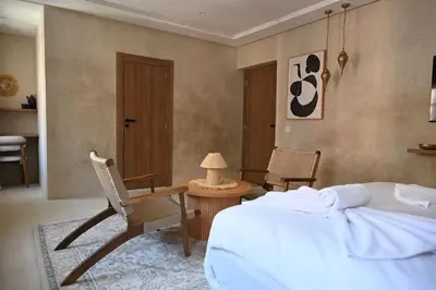 a bedroom with a bed and a table and chairs at Suite Oasis - cosy et moderne in Marrakech