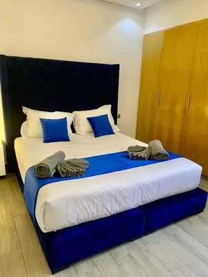 a large bed with blue and white sheets and blue pillows at Perfect pied-à-terre 1ch in Gueliz in Marrakech