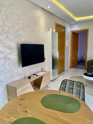 a living room with a table and a flat screen tv at Perfect pied-à-terre 1ch in Gueliz in Marrakech