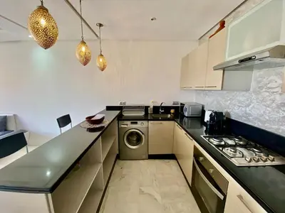a kitchen with a stove and a washer and dryer at Small 1-bedroom apartment perfect for discovering Marrakech in Marrakech