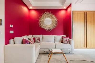 a living room with a white couch and a red wall at City Center-1 Queen BR with AC, Pool and IPTV- Parking in Marrakech