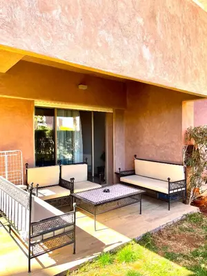 three benches sitting on a patio with a building at Prestihia jade in Marrakech