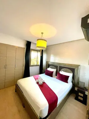 a bedroom with a large bed with red pillows at Prestihia jade in Marrakech