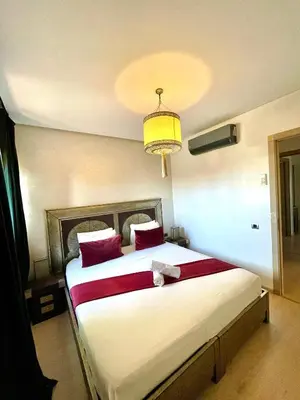 a bedroom with a large bed with red pillows at Prestihia jade in Marrakech