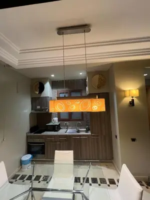 a kitchen with a glass table and a chandelier at Duplex Le Vizir for 6 with Park Access 3 Pools in Dar Caïd Layadi