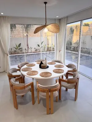 a dining room with a white table and chairs at Villa 289- Charme Balinais in Marrakech
