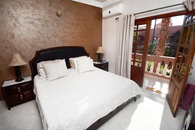 a bedroom with a bed with white sheets and a window at Villa Marrakech in Marrakech