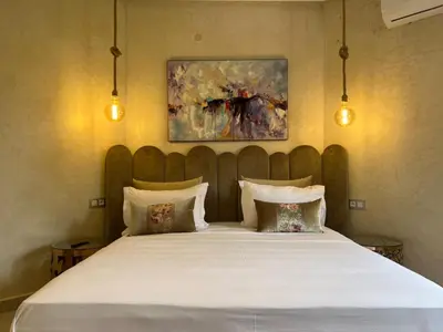 a bedroom with a large white bed with two pillows at ksar el bahja in Marrakech