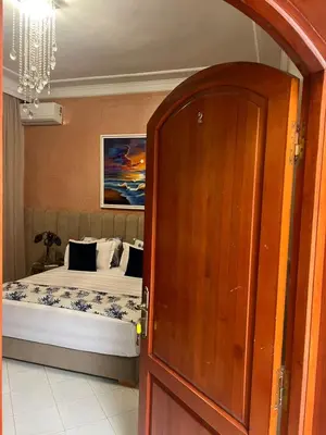 a bedroom with a bed and a wooden door at ksar el bahja in Marrakech