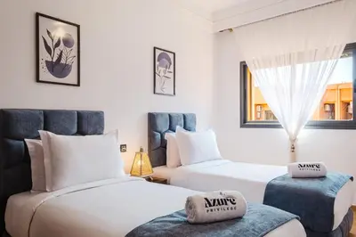 a hotel room with two beds and a window at Charming Apartment Guéliz Pool-Parking 24h-7j Security 10 a pied de M Avenue in Marrakech