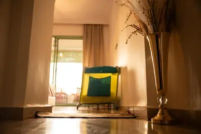 a yellow chair sitting in a room with a window at Hivernage, piscine & jardin privé in Marrakech