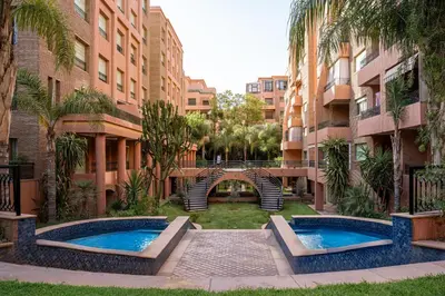 a courtyard with two swimming pools in a building at Hivernage, piscine & jardin privé in Marrakech