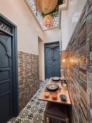 a dining room with a table and a blue door at DAR ZINA - Heart of Medina, Marrakech in Marrakech