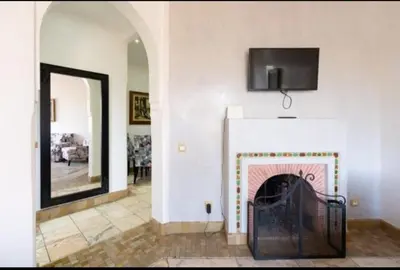 a living room with a fireplace with a tv above it at Palmeraie Village 2 in Marrakech