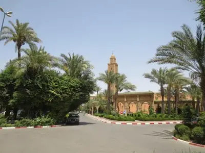 a car parked in front of a building with palm trees at Riad Four Rooms & Pool in Marrakech