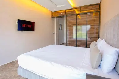 a bedroom with a white bed and a window at Villa Sérénité Marrakech in Marrakech