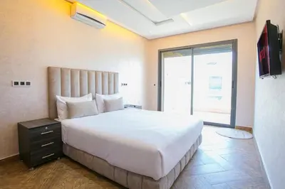 a bedroom with a large white bed and a window at Villa Sérénité Marrakech in Marrakech